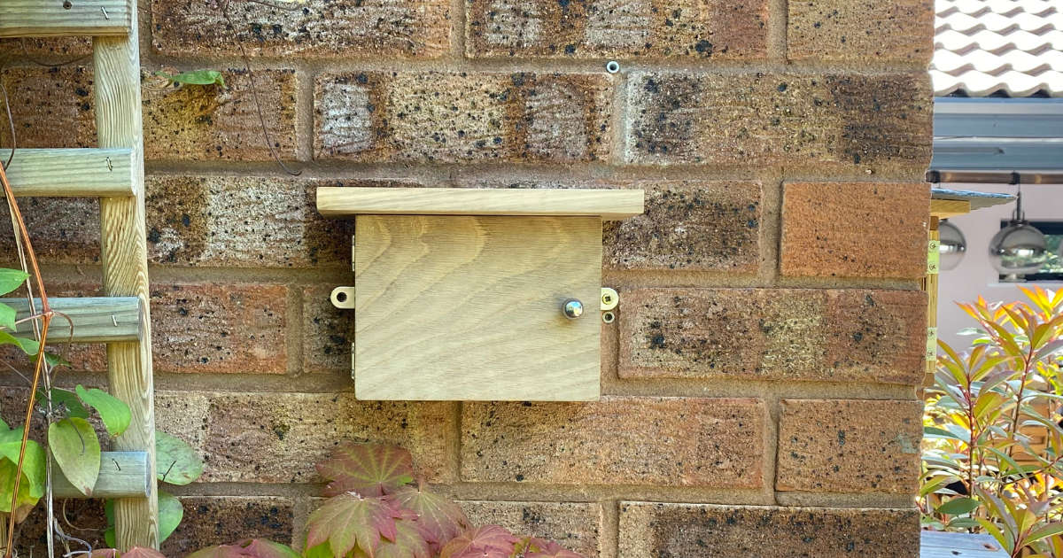 solid oak wood solitary bee house on wall in garden